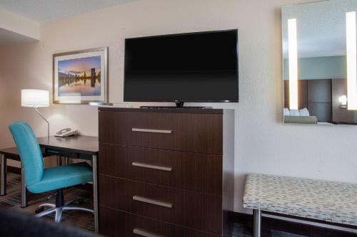a hotel room with a desk and a flat screen tv at Wingate By Wyndham - Orlando International Airport- Free Hot Breakfast in Orlando