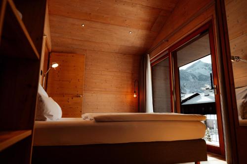 um quarto com uma cama e uma grande janela em Traumferienhaus 2 mit Sauna und Bergblick em Garmisch-Partenkirchen