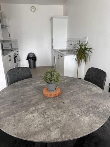 una cocina con una mesa con una maceta. en Recently Refurbished Apt central MK FREE PARKING en Milton Keynes