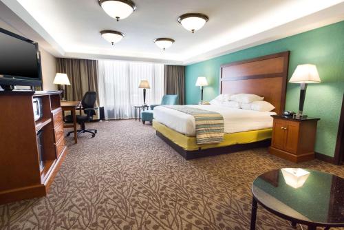 Drury Inn & Suites Atlanta Airport في أتلانتا: غرفه فندقيه سرير وتلفزيون