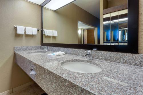 a bathroom with two sinks and a large mirror at Drury Inn & Suites Atlanta Airport in Atlanta