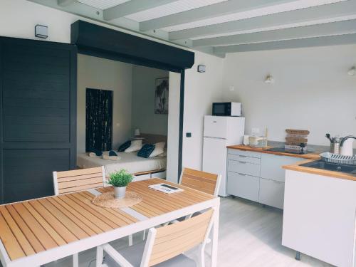 a kitchen with a table and a room with a bed at Archipel Maimeo in Saint-François