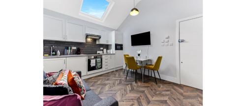a kitchen with a table and yellow chairs in a room at Cozy 1 BD Flat in London! in Romford