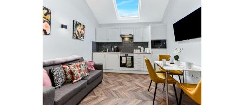 a living room with a couch and a table at Cozy 1 BD Flat in London! in Romford