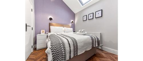 a bedroom with a bed with a black and white bedspread at Cozy 1 BD Flat in London! in Romford