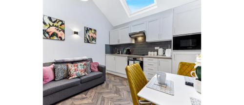 a living room with a couch and a table at Cozy 1 BD Flat in London! in Romford