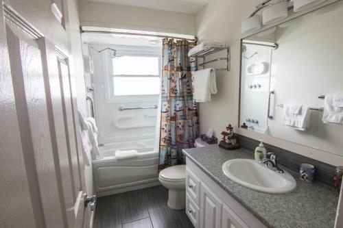 a bathroom with a sink and a toilet and a window at Anchors Away in Leamington