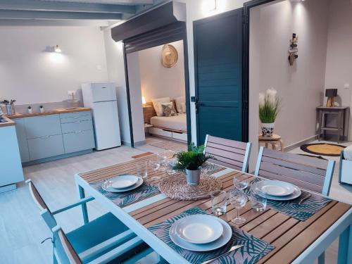 a dining room with a table with plates and wine glasses at Archipel Maimeo in Saint-François