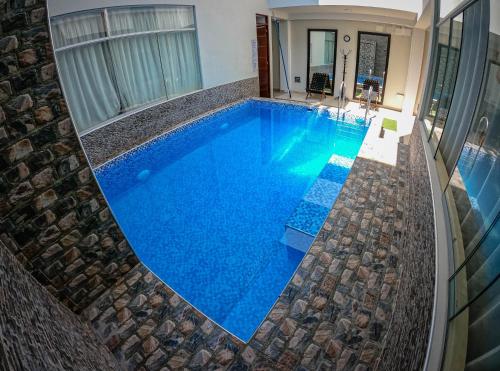 a swimming pool with blue water in a house at Hospedaje Rocio del Mar in Cerro Azul