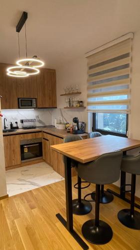 a kitchen with a wooden table and chairs in it at Lux apartment Sky Central Residence Zlatibor in Zlatibor