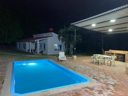 a blue swimming pool in a yard at night at Finca El Balmoral in Tocaima