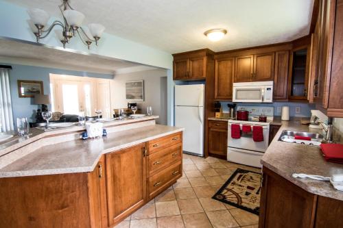 a kitchen with wooden cabinets and a white refrigerator at Anchors Away in Leamington