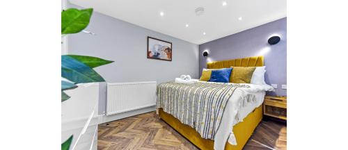 a bedroom with a bed with yellow and blue at Newly Renovated 1BD Flat Perfect for Travellers in Romford