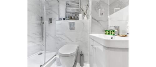 y baño blanco con ducha, aseo y lavamanos. en Newly Renovated 1BD Flat Perfect for Travellers en Romford