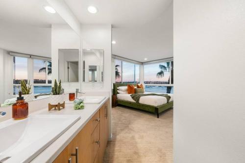 ein Badezimmer mit 2 Waschbecken und ein Schlafzimmer mit einem Bett in der Unterkunft Skyline Oasis: Luxe 3-Floor Waterfront Penthouse in Los Angeles