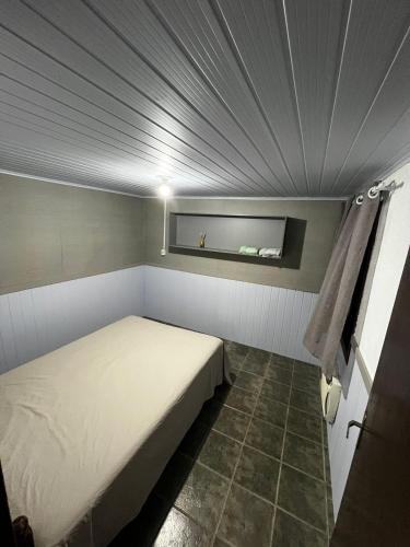 een kleine slaapkamer met een bed in een kamer bij Minha casa in Navegantes