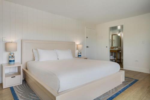 a white bedroom with a large white bed with white pillows at Hadley Resort and Marina in Islamorada