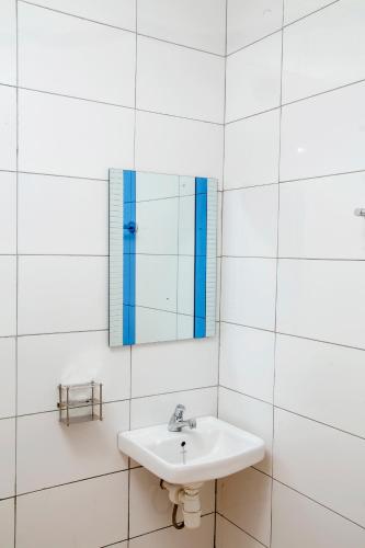 Baño blanco con lavabo y espejo en Eziana palm hotels, 