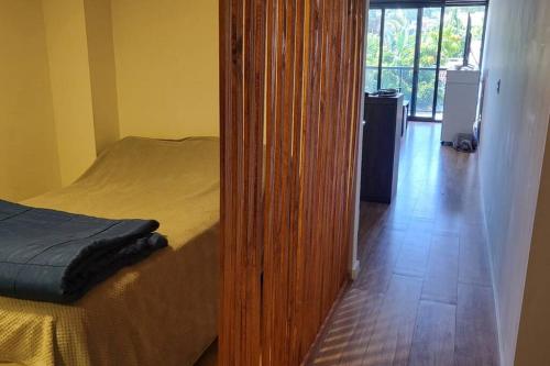 Hermoso apartamento en pocitos في مونتيفيديو: غرفة نوم بباب يؤدي الى سرير