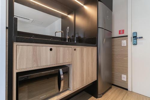 a kitchen with a sink and a refrigerator at Housi Paulista in Sao Paulo