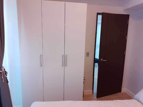 a bedroom with white cabinets and a black door at The City Escape in Cebu City