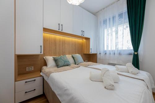 Un dormitorio con una cama grande con toallas. en Magic Mountain Apartment Zlatibor, en Zlatibor