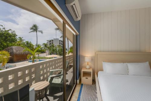 イスラモラダにあるHadley Resort and Marinaのベッドルーム1室(ベッド1台付)、景色を望むバルコニーが備わります。