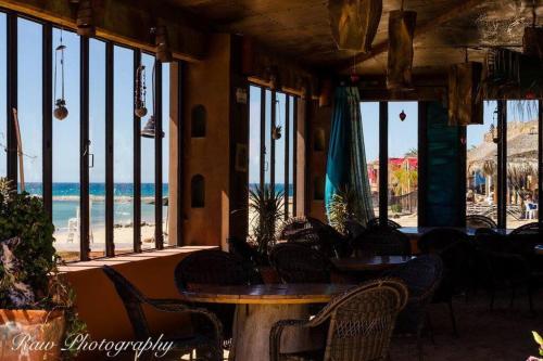 a restaurant with tables and chairs and a view of the beach at Lot # 7 ~ Large, Energetic Baja House in Guaymas