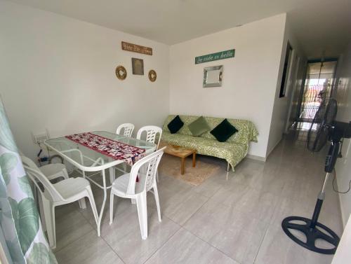 ein Esszimmer mit einem Tisch, Stühlen und einem Sofa in der Unterkunft Acogedora Casa cerca a la playa in Pisco