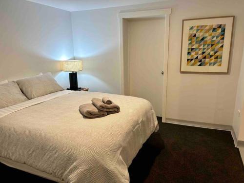 a bedroom with a bed with a towel on it at Stylish Sandy Bay Apartment in Sandy Bay