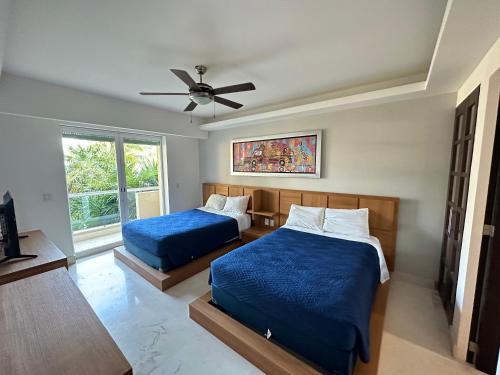 a bedroom with two beds and a ceiling fan at The Beach Residences in Puerto Morelos