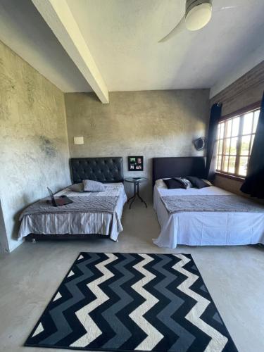 Habitación con 2 camas y alfombra. en Suítes classic, en Búzios