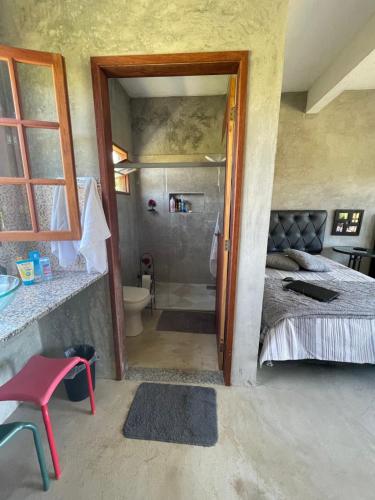 1 dormitorio con 1 cama y baño con ducha en Suítes classic, en Búzios