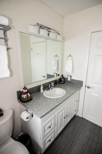 a bathroom with a sink and a toilet and a mirror at Anchors Away in Leamington