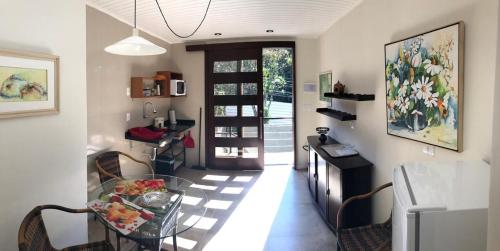 uma sala de estar com uma mesa de vidro e uma cozinha em Studio Carini em Curitiba