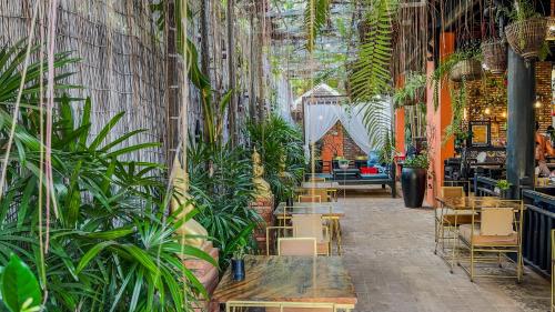a restaurant with plants and tables and chairs at Residence Indochine D'angkor in Siem Reap