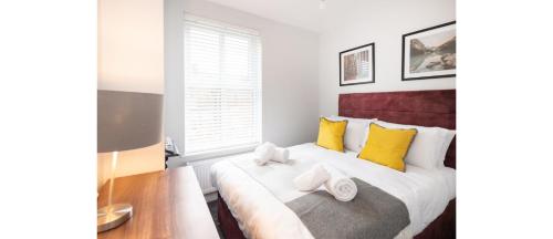 a bedroom with a large bed with yellow pillows at Hassle-Free & Handsome Brand-New 3-Bed Home in Manchester