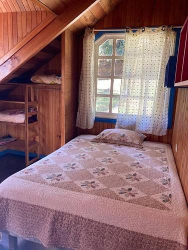 um pequeno quarto com uma cama e uma janela em La Cabaña: Descanso y Naturaleza em Cartago