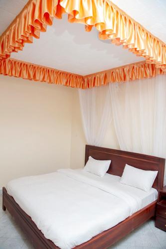 - une chambre avec un lit à baldaquin orange dans l'établissement Eziana palm Hotels, 