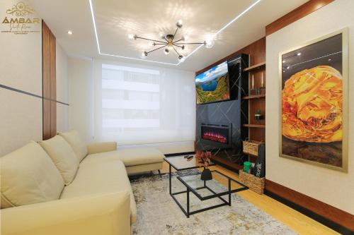 a living room with a white couch and a tv at Ámbar Suite Room / lujo y confort únicos in Quito