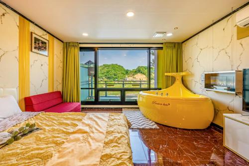 a bedroom with a large bed and a large window at Hongcheon Botopia Healing Park in Hongcheon