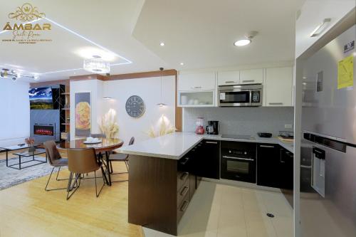 a kitchen with white cabinets and a table with chairs at Ámbar Suite Room / lujo y confort únicos in Quito