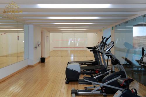 a gym with cardio equipment and a basketball court at Ámbar Suite Room / lujo y confort únicos in Quito