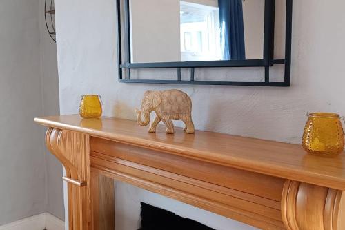 a wooden elephant figurine on top of a fireplace at Harbor View in Valentia Island