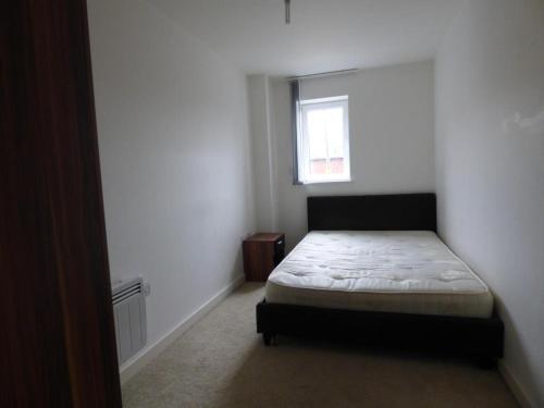 a small bedroom with a bed and a window at The Light Buildings in Preston