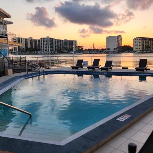 a large swimming pool with chairs and water at By the Beach Rentals in Clearwater Beach