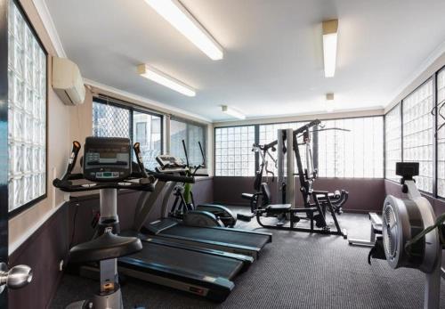 - une salle de sport avec plusieurs appareils d'exercice dans une pièce dotée de fenêtres dans l'établissement 73 Peaceful &private 2brgymparkng, à Perth