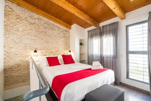 セビリアにあるPlaza de Armasのベッドルーム(赤い枕の大きな白いベッド付)