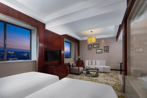 a hotel room with a bed and a living room at Enlux Hotel in Jinan