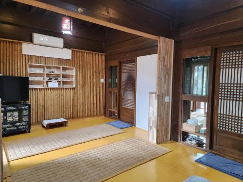 a living room with wooden walls and a television at HanokInn in Gyeongju